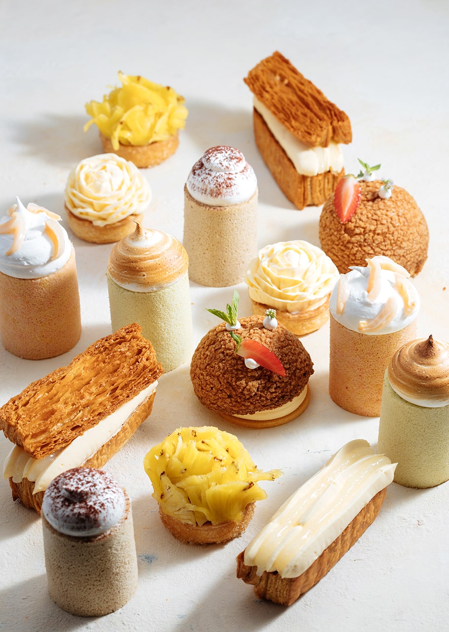 Collection de pâtisseries fines françaises avec éclairs, religieuses, tartelettes et macarons décorés