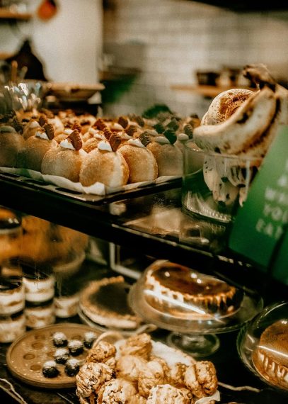 Vitrine de boulangerie avec pâtisseries artisanales : macarons, éclairs, pains d'épices et gâteaux décorés
