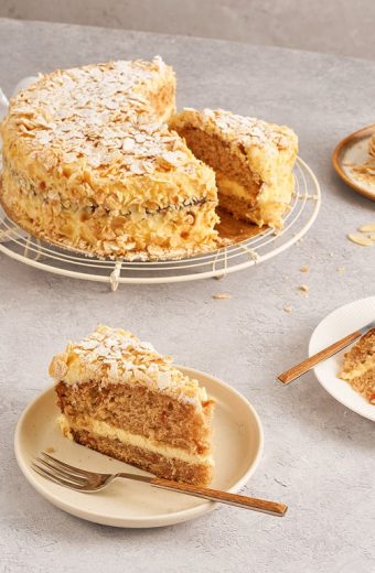 Gâteau aux amandes avec glaçage et éclats d'amandes, tranches servies sur assiettes avec fourchettes