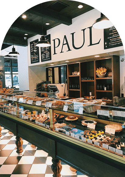 Boulangerie Paul avec vitrine de pâtisseries et viennoiseries artisanales, comptoir vert et sol en damier noir et blanc