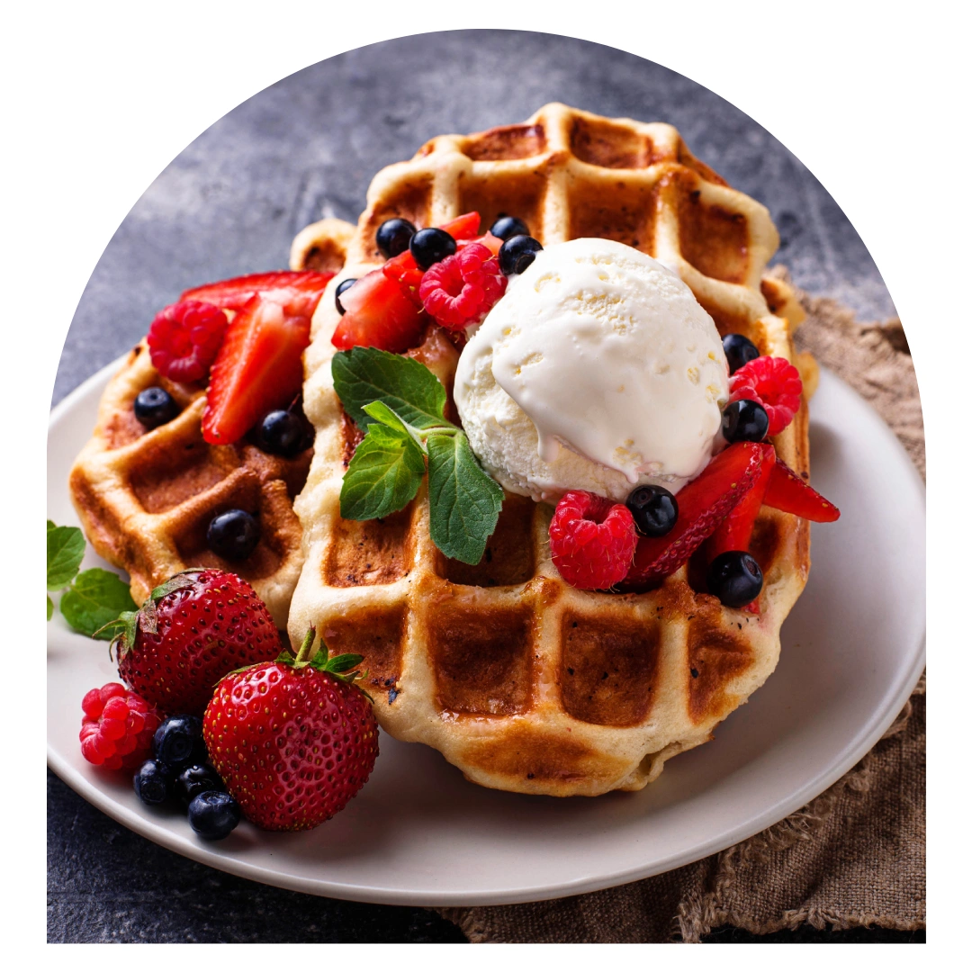Gaufre de Liège dorée garnie de glace vanille, fraises, framboises et myrtilles fraîches avec feuille de menthe