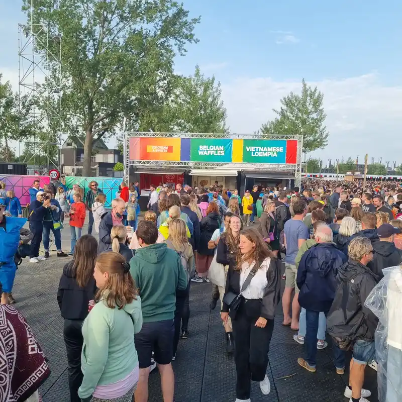 Foule de visiteurs dans un marché ou festival culinaire avec stand de restauration proposant des spécialités belges