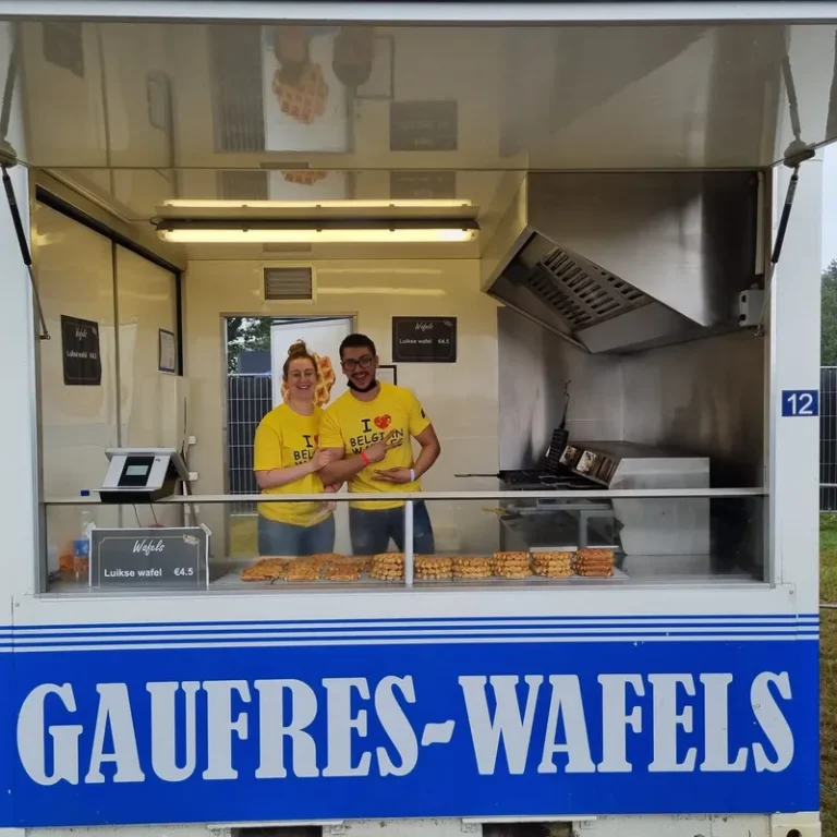 Deux vendeurs en t-shirt jaune devant un food truck Gaufres-Wafels avec vitrine de gaufres de Liège artisanales