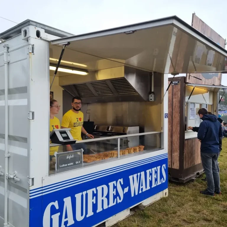 Food truck Gaufres-Waffels avec deux vendeurs en jaune servant des gaufres de Liège artisanales à un client