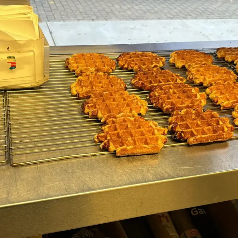 Gaufres de Liège artisanales dorées fraîchement cuites alignées sur une grille de refroidissement en métal