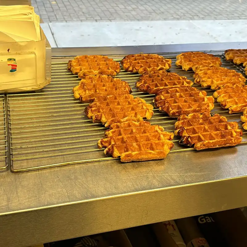 Gaufres de Liège artisanales dorées fraîchement cuites alignées sur une grille de refroidissement en métal