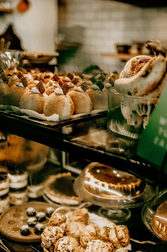 Vitrine de boulangerie avec pâtisseries artisanales : macarons, éclairs, pains d'épices et gâteaux décorés
